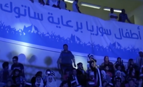 جمهور منتخب سوريا للأيتام يساندون المنتخب بأعلام الثورة